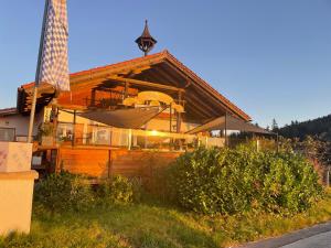 a wooden house with an umbrella in front of it at Arber Alm in Bayerisch Eisenstein
