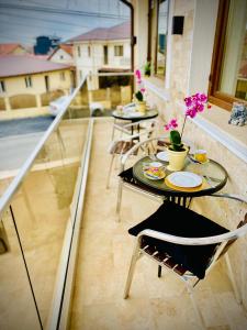 a patio with two tables and chairs on a balcony at IANIS Rooms in Mangalia