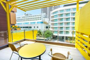 a balcony with a table and chairs and a building at Mood Hotel Pattaya in Pattaya Central