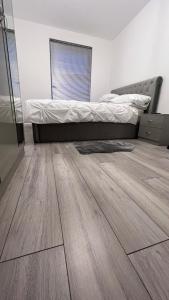 a bedroom with a bed and a wooden floor at Lovely and comfortable Home Stay in London in London