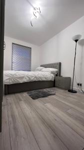 a bedroom with a bed and a wooden floor at Lovely and comfortable Home Stay in London in London