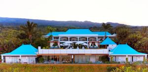 a building with blue roofs on top of a hill at Blue Margouillat Seaview Hotel-RELAIS & CHATEAUX in Saint-Leu