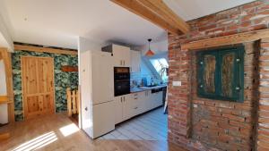 a kitchen with a brick wall and white appliances at Ostoja Leśna Cisza 