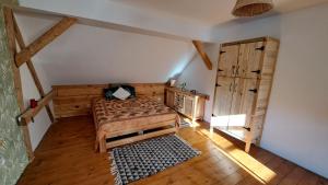 - une chambre avec un lit et du parquet dans l'établissement Ostoja Leśna Cisza, 