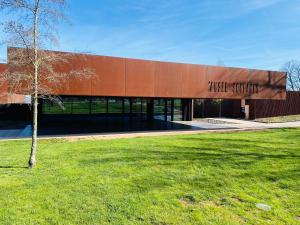 um edifício com uma árvore em frente em LE CLOS RUTHÈNE em Rodez