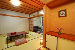 um quarto com uma sala de estar com uma mesa e um sofá em Yumoto Kobayashi em Kurume