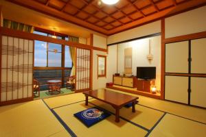a living room with a table and a television at Yumoto Kobayashi in Kurume