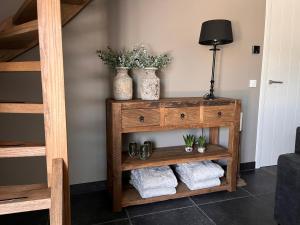 una estantería de madera con dos jarrones y toallas. en Bed en wellness de Heyde, en Veghel