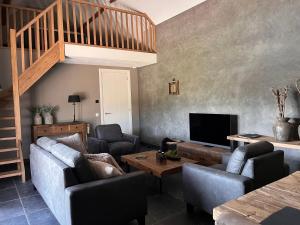 uma sala de estar com um sofá e uma televisão em Bed en wellness de Heyde em Veghel
