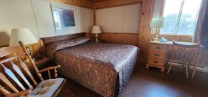 Schlafzimmer mit einem Bett, einem Schreibtisch und einem Stuhl in der Unterkunft Auberge Motel 4 Saisons in Blanc-Sablon