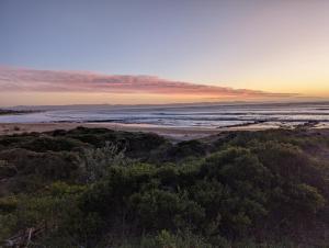 vista para a praia ao pôr-do-sol em @Kitchens em Jeffreys Bay