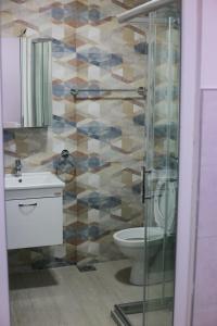 a bathroom with a toilet and a glass shower at Cholakovi Apartments in Veles