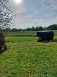 ein großes schwarzes Fass, das auf einem Grasfeld sitzt in der Unterkunft Marija in Krāslava