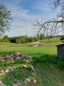 a field with a pile of rocks and a building at Marija in Krāslava