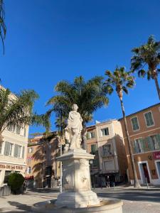 a statue in the middle of a street with palm trees at Casa Paloma in Sanary-sur-Mer