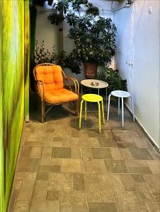 una silla naranja y dos mesas en una habitación en Park, en Agioi Theodoroi
