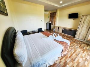 um quarto de hotel com uma cama com toalhas em So View Phuket Resort em Ban Sam Kong
