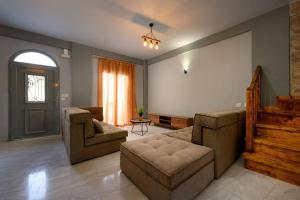 a living room with a couch and chairs and a door at Anastasia&Filippos house in Ágios Matthaíos