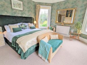 a bedroom with a large bed with a mirror and a chair at Foxhills of Shanklin in Shanklin