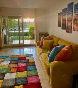 a living room with a yellow couch and a colorful rug at Sunset apartment, front line Mijas Golf in Mijas