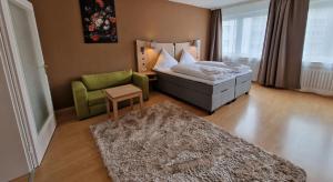 1 dormitorio con 1 cama, 1 silla y 1 alfombra en Center Hotel Essen en Essen