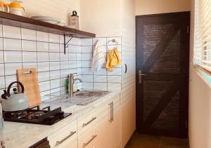 a kitchen with a sink and a stove and a door at Moon Landscape Self Catering in Swakopmund