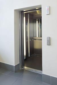 a glass door of a elevator in a building at Apartament Na Wydmie, garaż + ładowarka EV in Ustka +11 photos