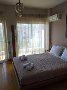 a bedroom with a large bed with two towels on it at Villa Palmyra Athens in Athens