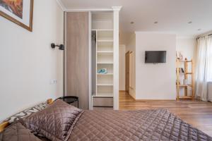 ein Schlafzimmer mit einem Bett und einem TV in einem Zimmer in der Unterkunft Murnieku residence in Riga