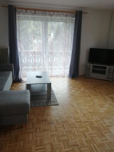sala de estar con sofá y mesa frente a una ventana en Wohnung Gretl, en Bayerisch Eisenstein