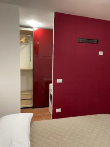 1 dormitorio con puerta roja y microondas en monolocale piano terra vicino aeroporto en Porto