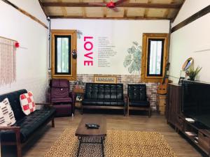 a living room with black leather furniture and a tv at Sali Mu Homestay in Taian