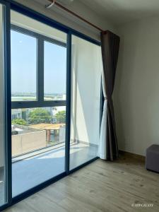 an empty room with a sliding glass door at ATP Galaxy Hotel & Apartment Danang in Da Nang