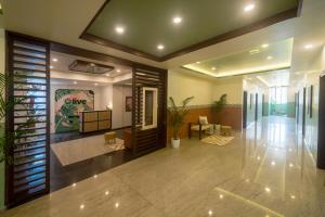 un hall de bureau avec un couloir orné de plantes dans l'établissement Olive Electronic City - by Embassy Group, à Bangalore