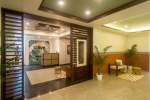 a lobby with a waiting room with plants at Olive Hotel Electronic City by Embassy Group in Bengaluru