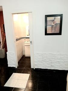 baño con puerta blanca y suelo de baldosa en Bienvenidos en San Pedro