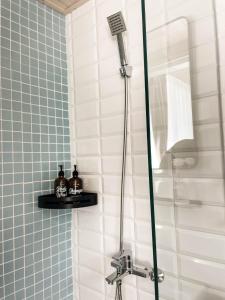 uma casa de banho com um chuveiro com azulejos azuis e brancos em Good Stay em Tainan