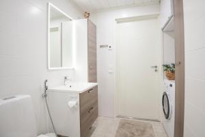 a bathroom with a shower and a toilet and a sink at Aurinkoranta Apartments by Hiekka Booking in Kalajoki +77 photos