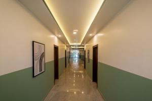 Olive Electronic City - by Embassy Group في بانغالور: ممر في مبنى به جدران خضراء وبيضاء