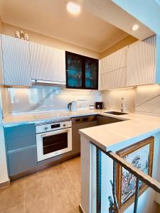 eine Küche mit weißen Schränken und einer Arbeitsplatte in der Unterkunft Port Mansion in Marmaris