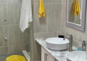 a bathroom with a white sink and a shower at Moon Landscape Self Catering in Swakopmund