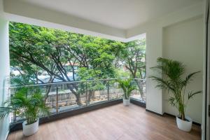 une chambre vide avec un balcon arboré dans l'établissement Olive Electronic City - by Embassy Group, à Bangalore