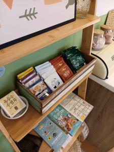 półka z książkami i innymi rzeczami na niej w obiekcie Good Stay w mieście Tainan