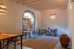 een kamer met tafels en stoelen en een stenen muur bij Agroturisme Subies in Selva
