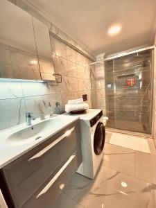 a bathroom with a sink and a washing machine at Port Mansion in Marmaris