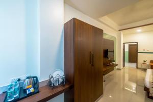 a bathroom with a wooden cabinet in a room at Olive Hotel Electronic City by Embassy Group in Bengaluru