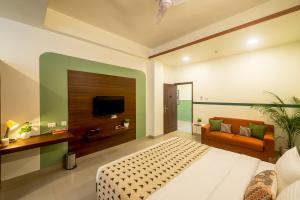 a bedroom with a bed and a tv and a couch at Olive Hotel Electronic City by Embassy Group in Bengaluru