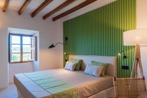 1 dormitorio con 1 cama con pared verde en Agroturisme Subies en Selva