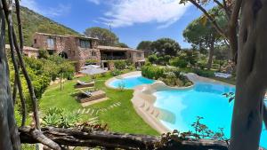een resort met een zwembad en een gebouw bij Hôtel Ambassador Palombaggia in Porto-Vecchio