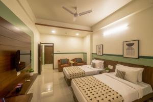 a hotel room with two beds and a tv at Olive Hotel Electronic City by Embassy Group in Bengaluru